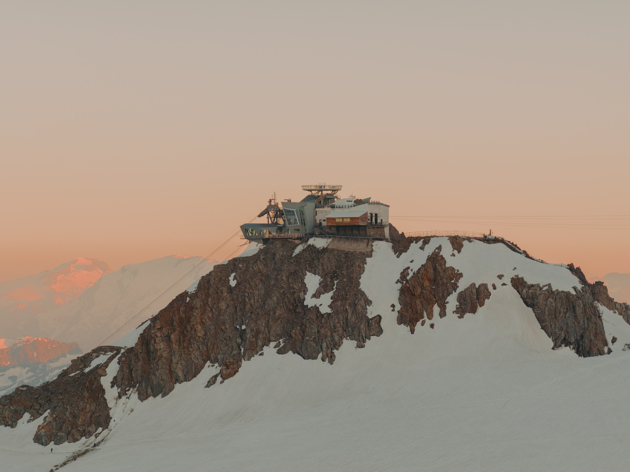 Skyway station on its rocky summit against a pink sky