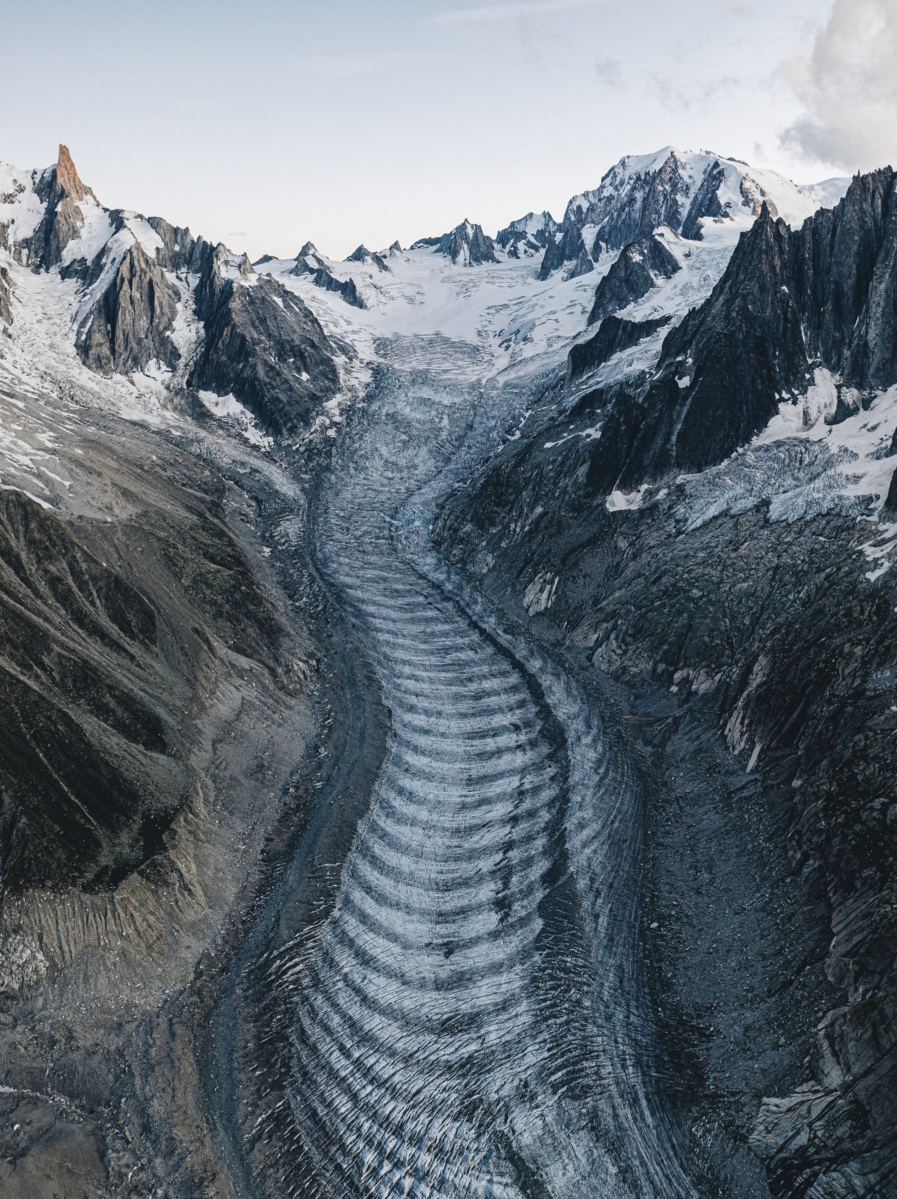 The curves and crevasses of the Tacul glacier between rock faces