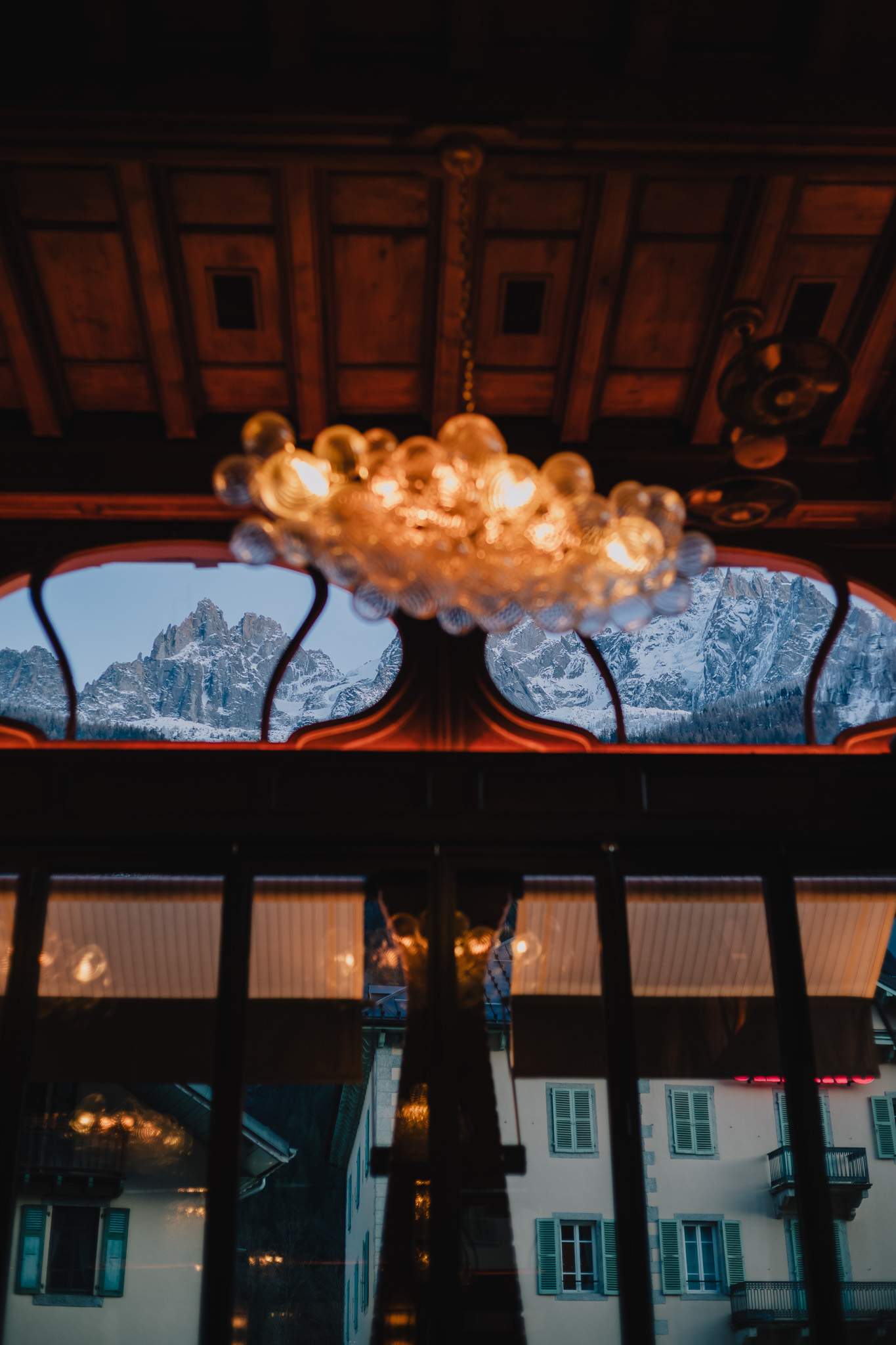 Un lustre devant les fenêtres laissant voir les sommets de Chamonix