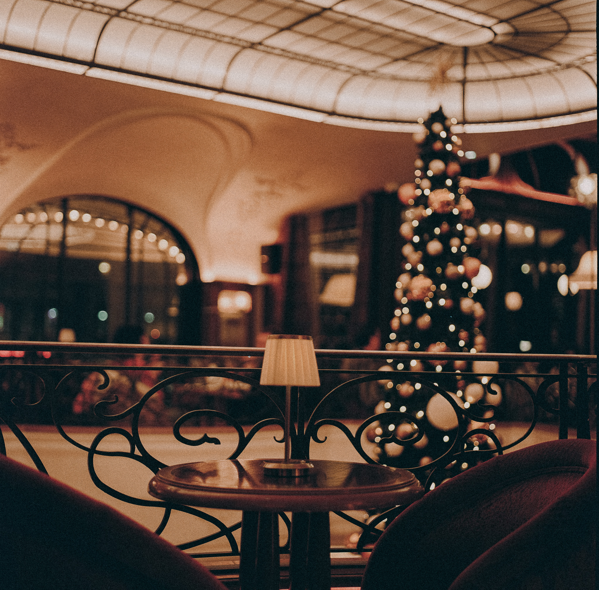 Une table et des fauteuils face au sapin de Noël, sous la verrière